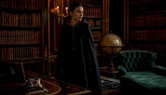 Fashion model showcasing exclusive black cloak in luxury atelier